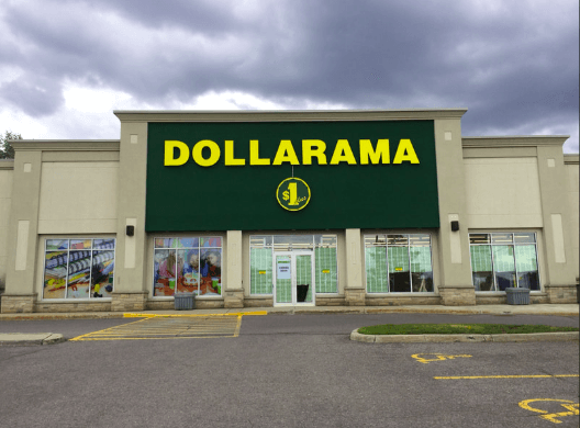 Dollarama storefront with a large green sign and yellow lettering under an overcast sky.